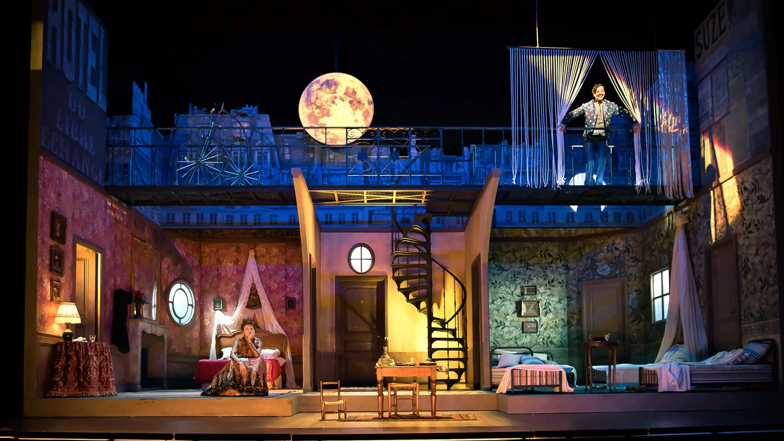 Cut-out house set against a starry sky, seen from the auditorium