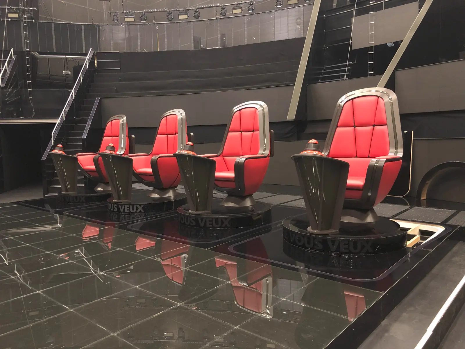 Row of bespoke red armchairs on plinths in an installation