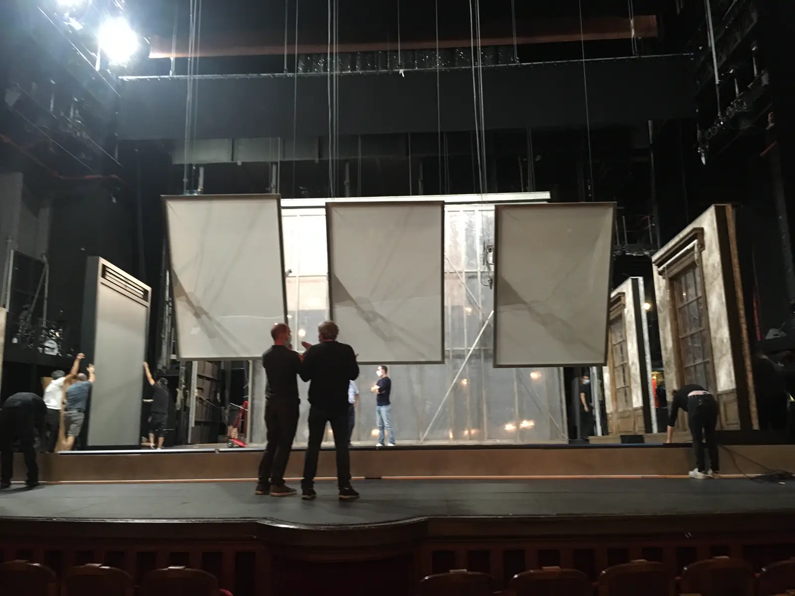 Large translucent panels being rigged on a stage