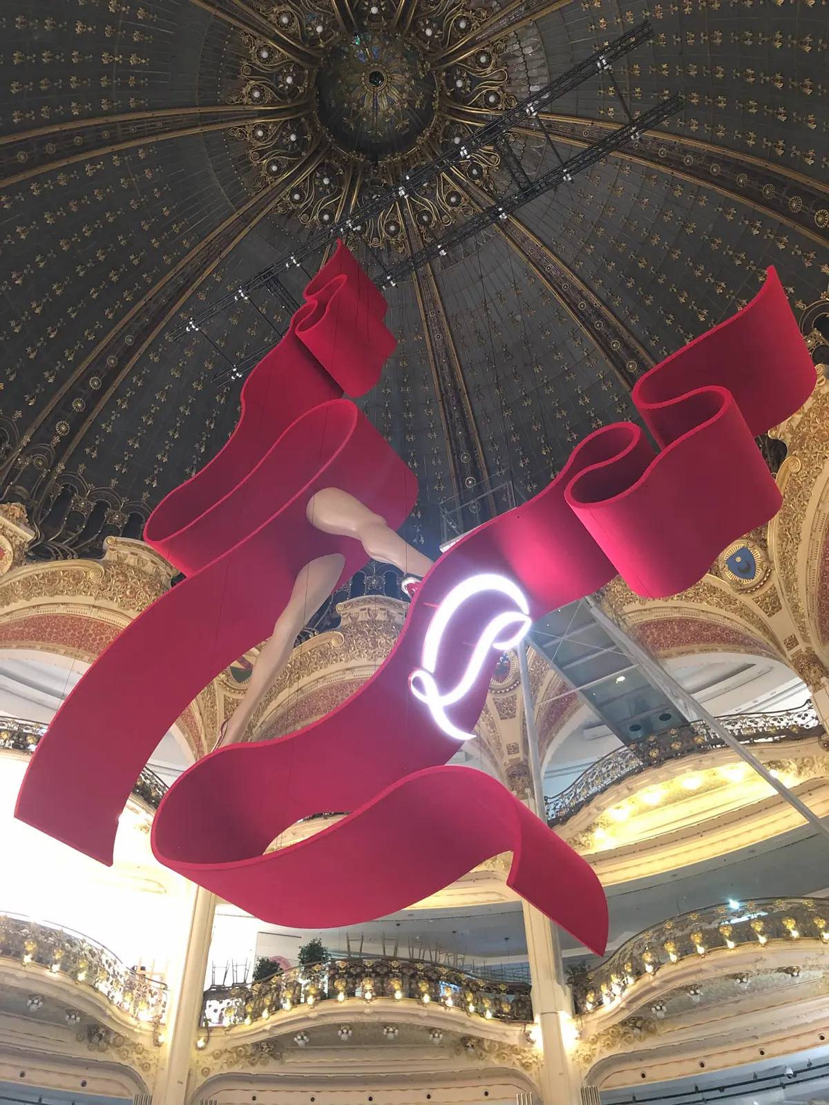 Red textile sculpture suspended beneath an ornate dome