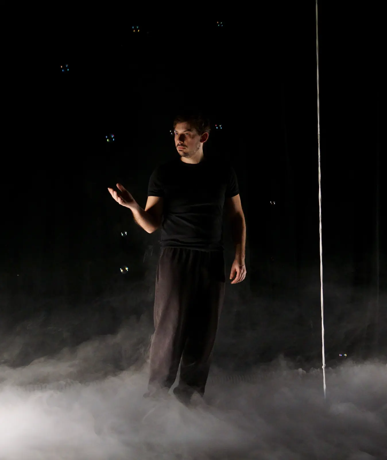 Silhouette emerging from a cloud of smoke on a dark stage
