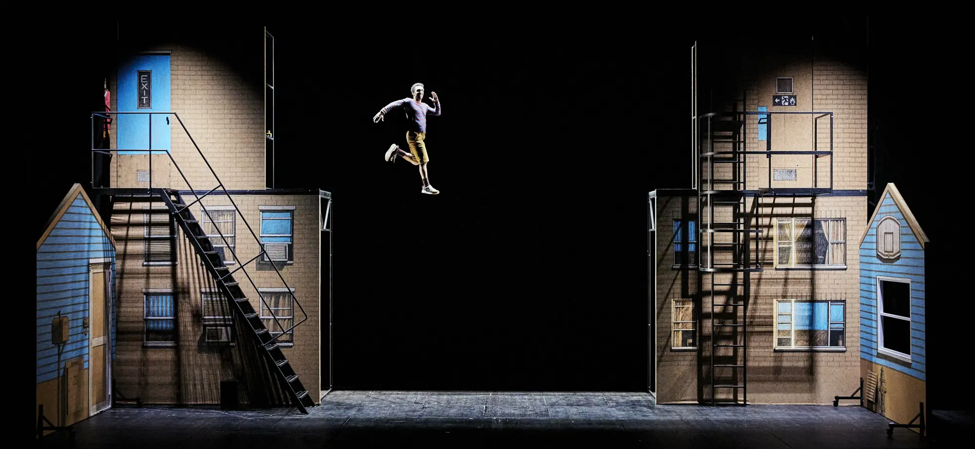 Performer levitating above the stage in front of scenic façades